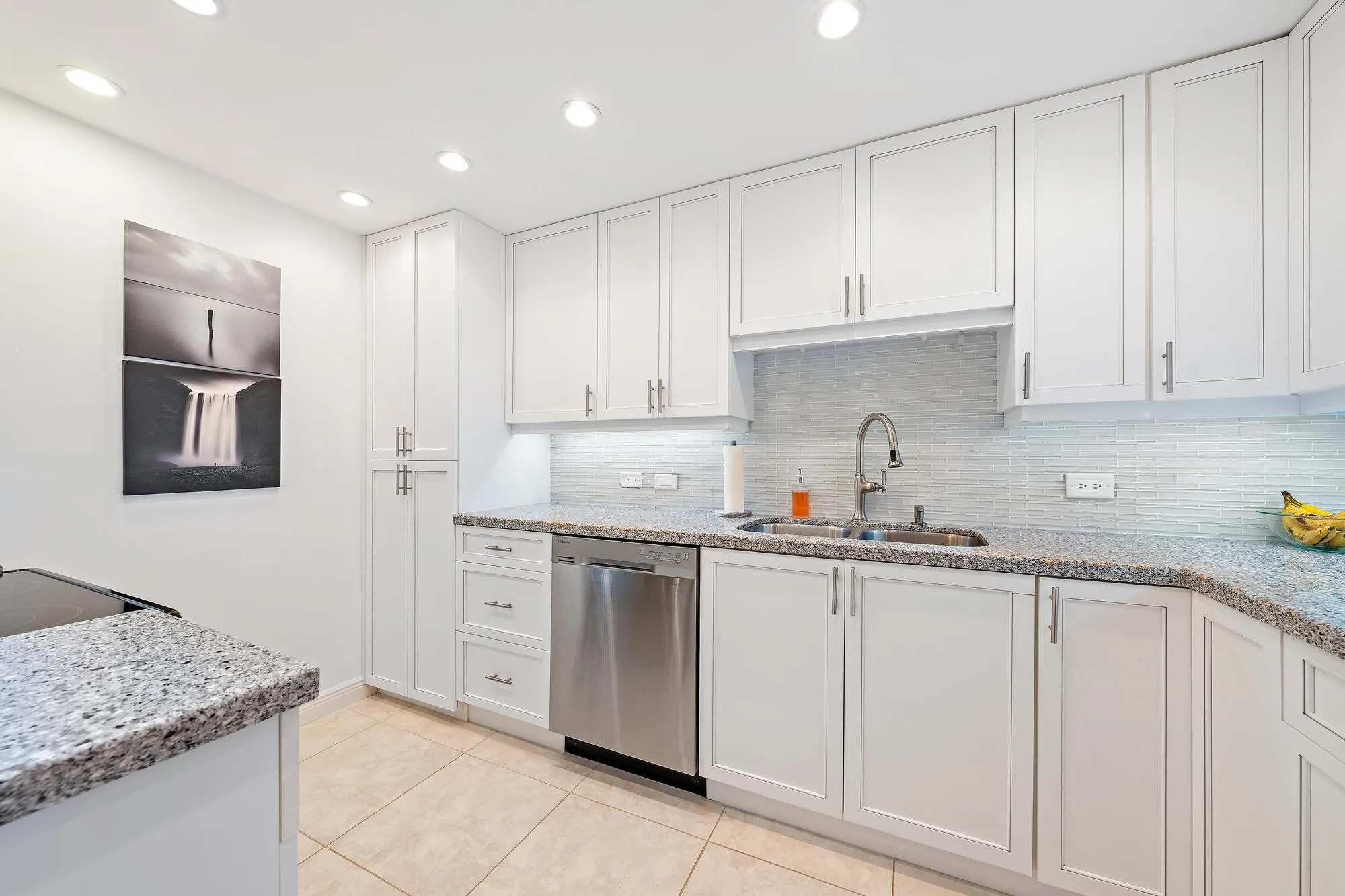 Updated kitchen with white cabinets and bright finishes.