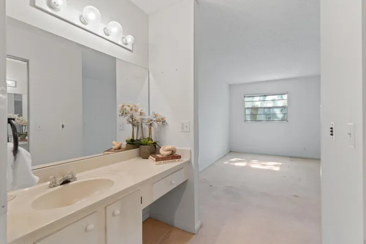 Private screened patio offering a peaceful outdoor setting with lush green views. Covered and screened for year-round comfort, ideal for morning coffee or relaxing evenings.