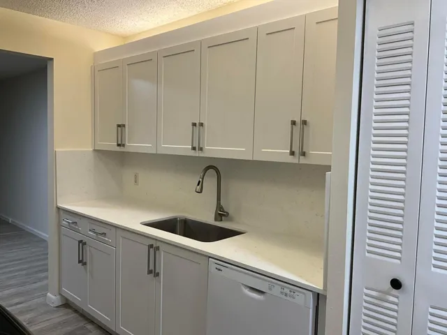 Stunning new kitchen with shaker cabinetry, quartz countertops & backsplash, new sink, faucet, flat cooktop stove/oven and microwave and a newer dishwasher and refrigerator.