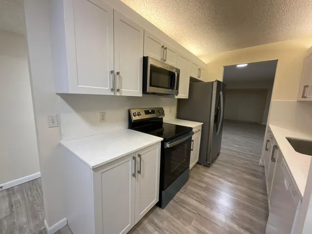 Stunning new kitchen with shaker cabinetry, quartz countertops & backsplash, new sink, faucet, flat cooktop stove/oven and microwave and a newer dishwasher and refrigerator.