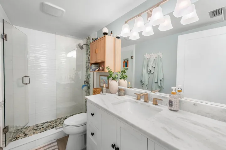 Primary Bath is tastefully remodeled with quartz counters and pebble tile shower floor.