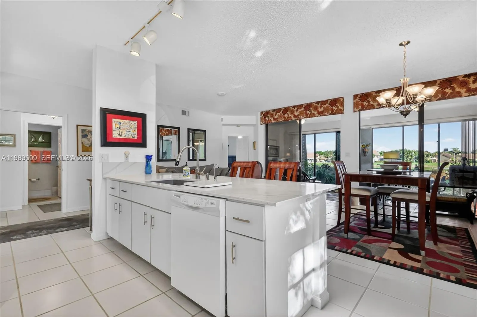 The open kitchen is positioned to capture the tranquil fairway and water views