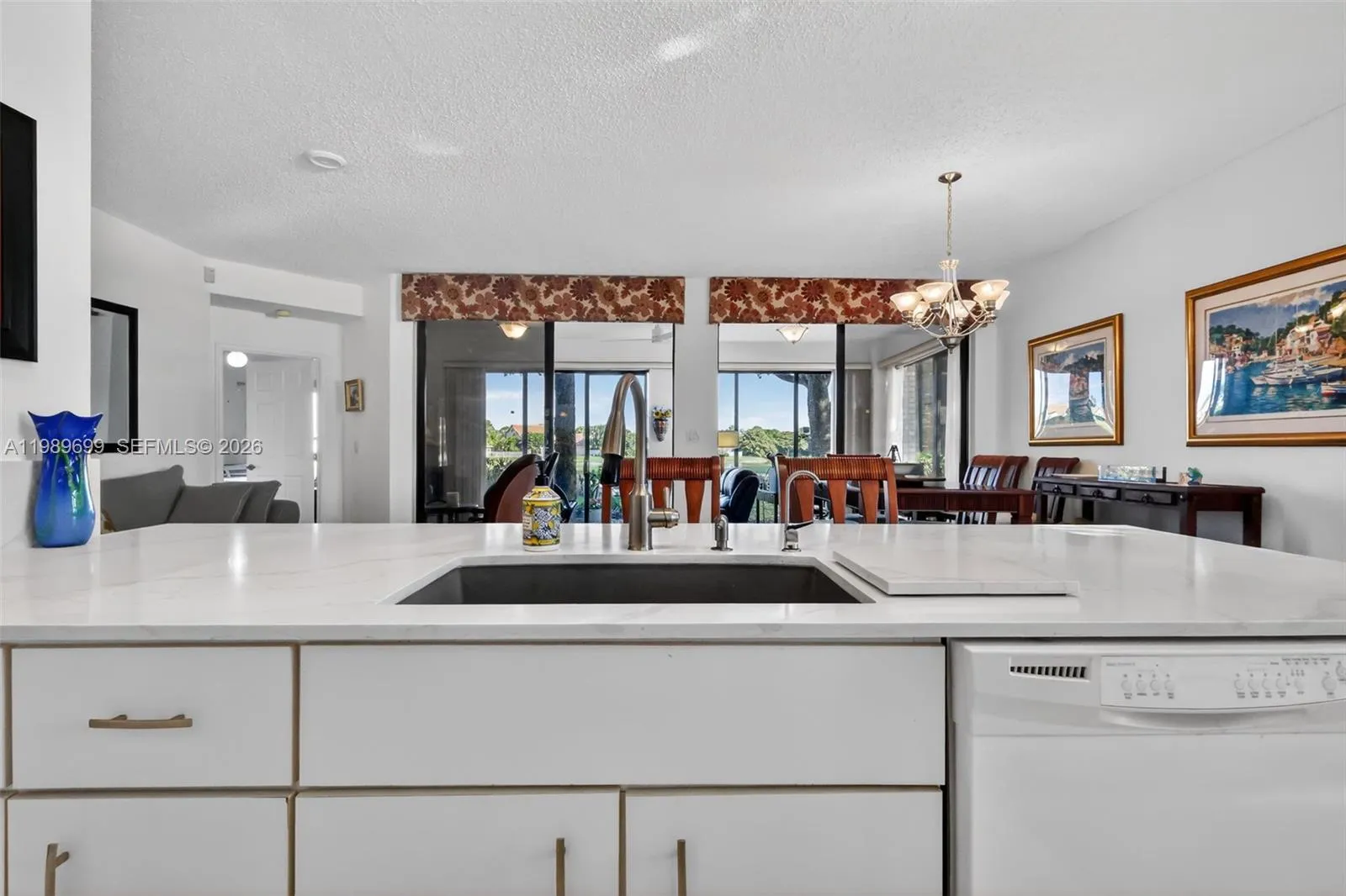 The open kitchen is positioned to capture the tranquil fairway and water views