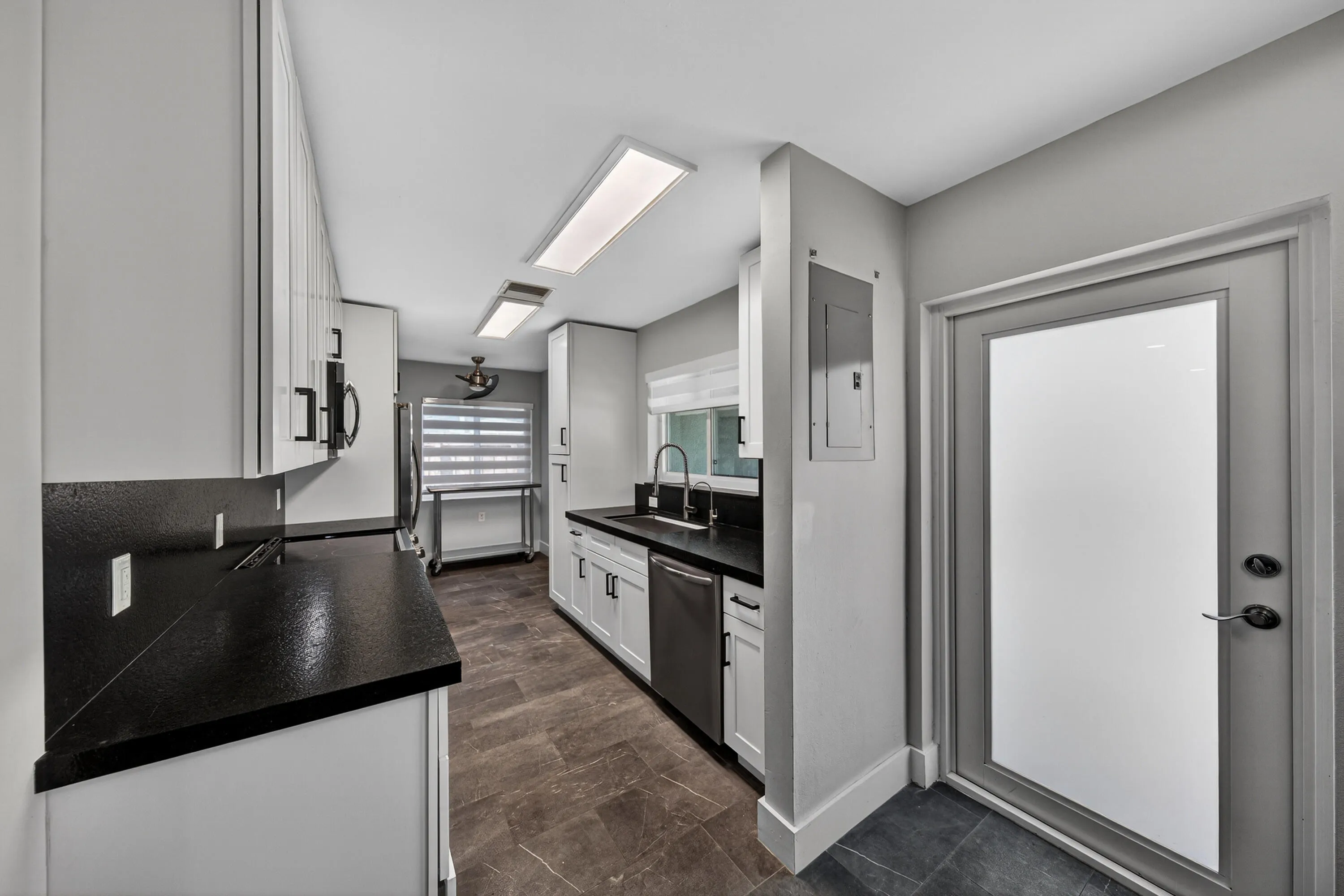 Renovated interior with matte porcelain floors, new soft close wood cabinets and matte granite counters.