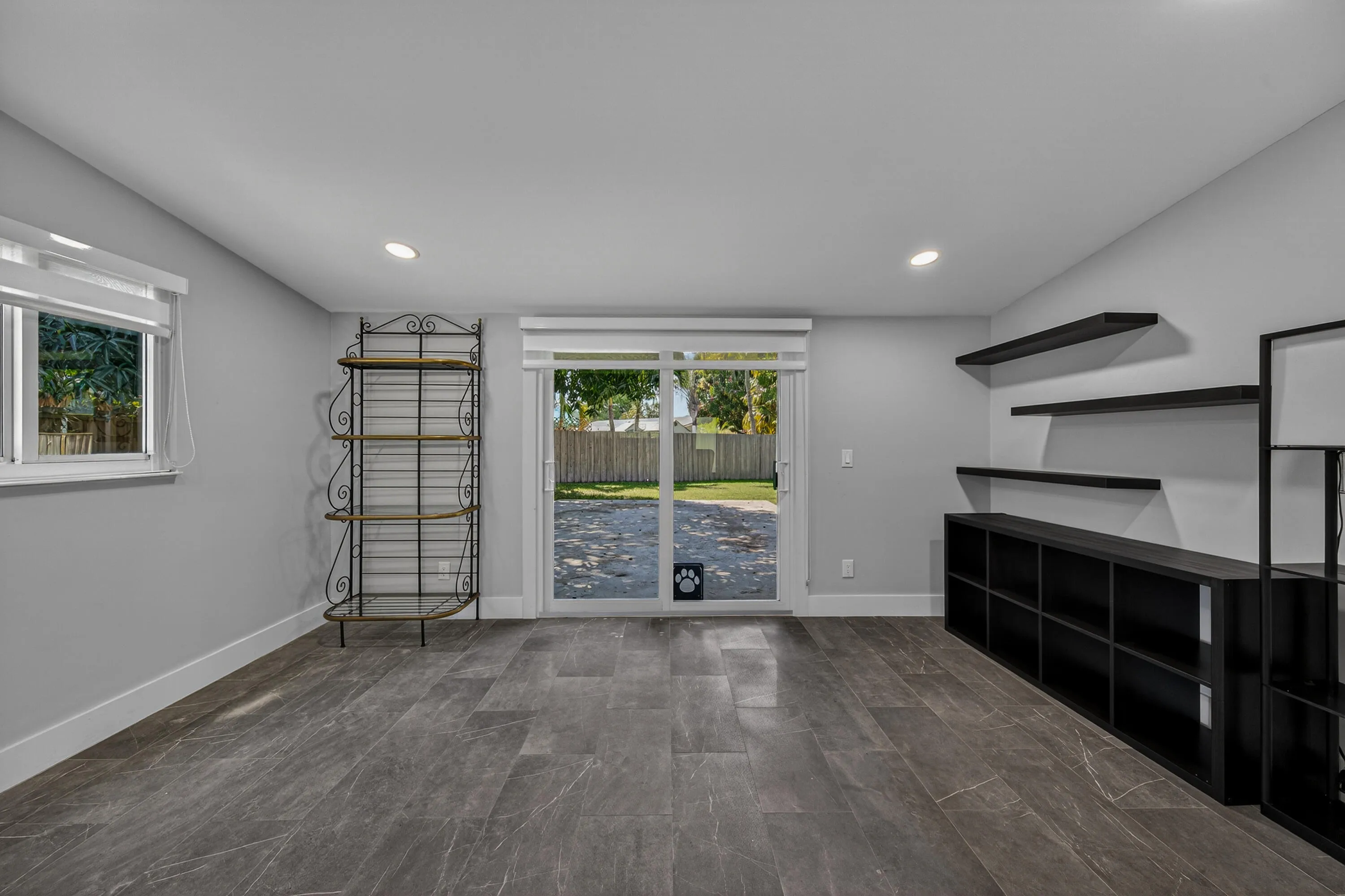 Den with impact sliders out to large patio and huge backyard.