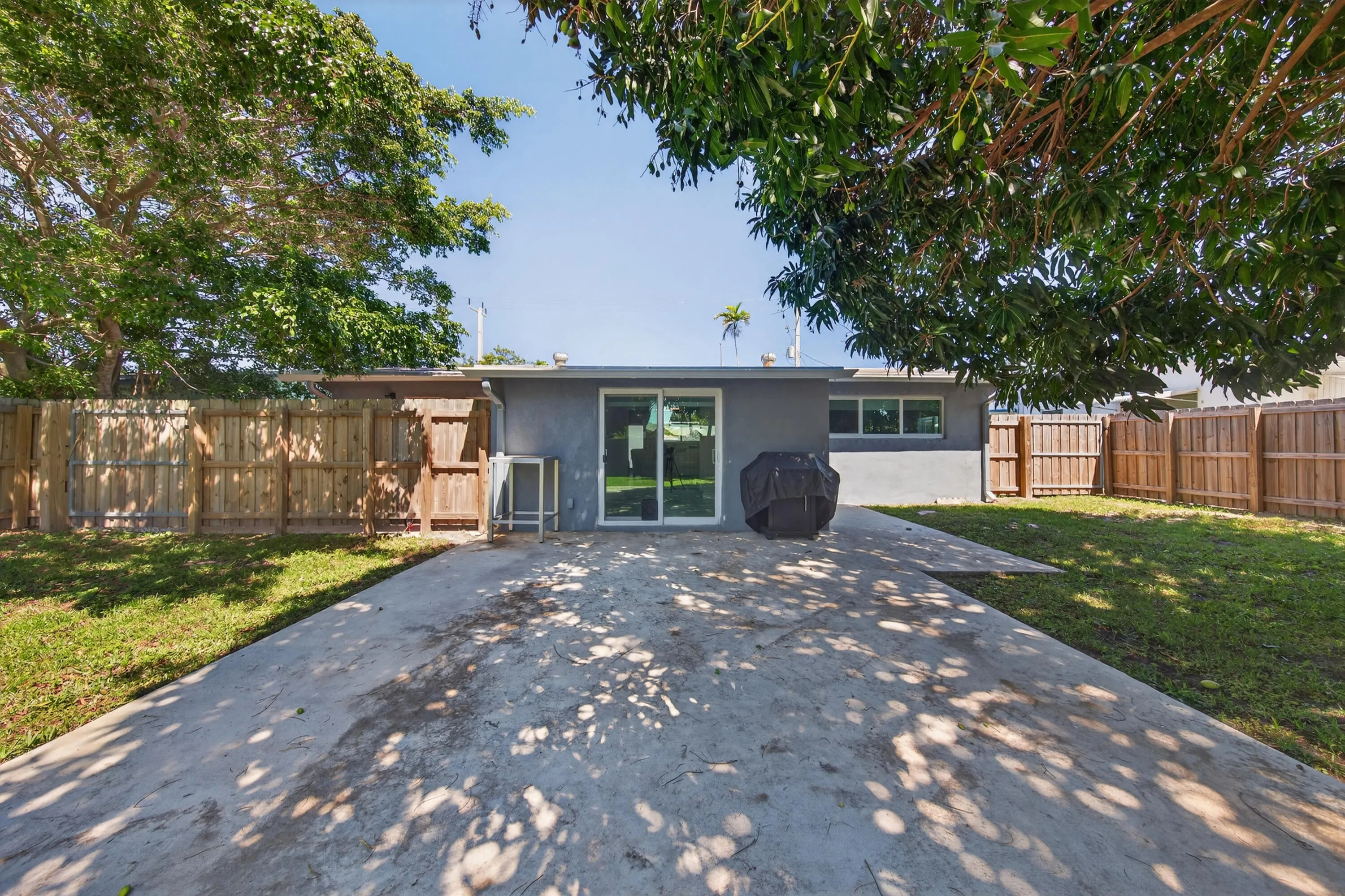 Back of house features patio and huge yard with fruit trees-mango and star fruit.