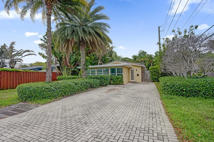 Inviting front exterior with spacious paver driveway with ample parking