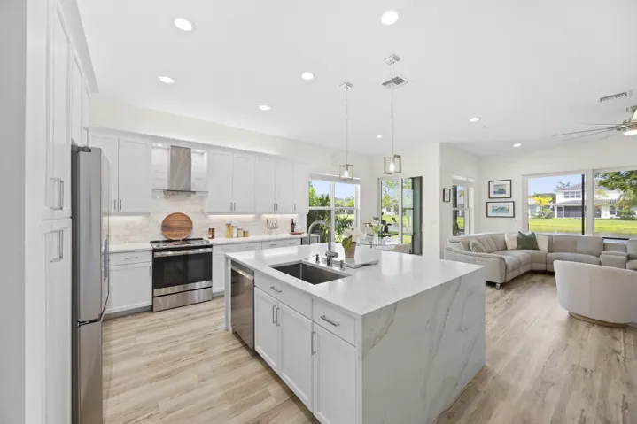 Open concept floor plan, with white shaker cabinets and Calacatta gold quartz tops and expanded kitchen island.