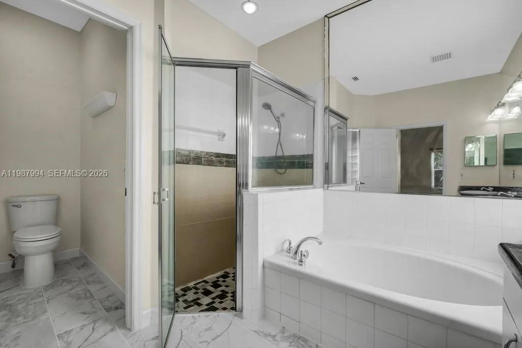 Main suite bath with separate shower, tub and toilet closer