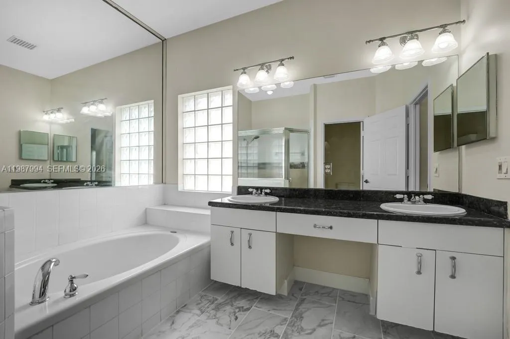 Main suite bath with separate shower and tub, dual sink