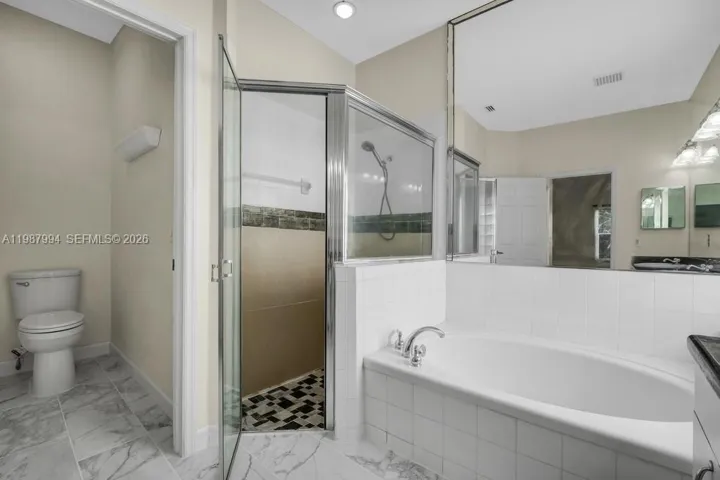 Main suite bath with separate shower, tub and toilet closer