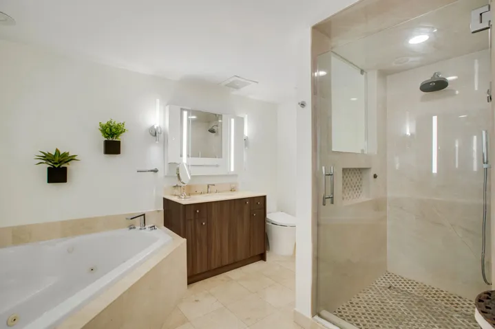 features two vanities, a jet bathtub, and a spacious shower