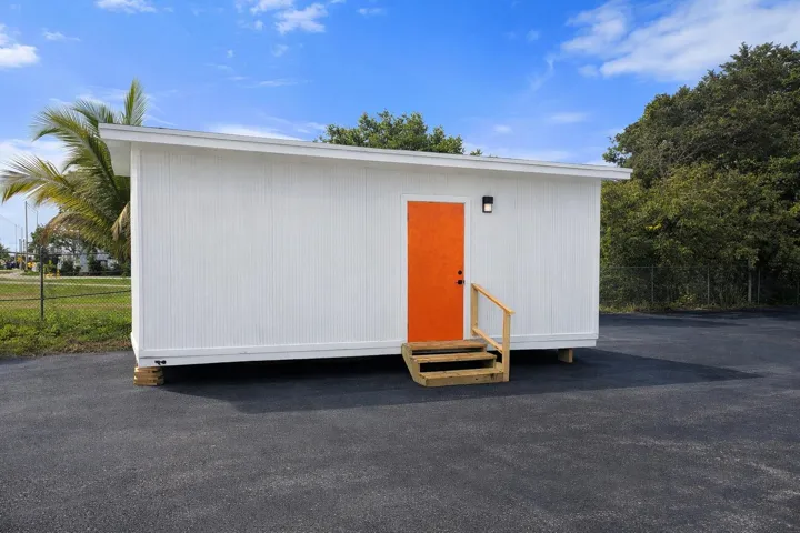 Bright orange door on white building