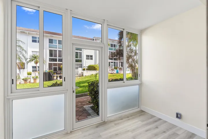 IMPACT GLASS ENCLOSED PATIO WITH DIRECT ACCESS TO COURTYARD POOL, BBQ AREA, SHUFFLEBOARD, AND CANAL BREEZEWAY.