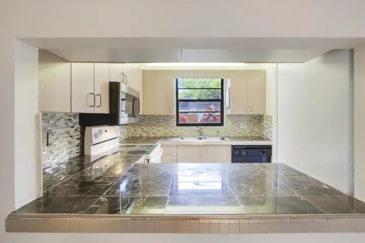There is an open window from the kitchen to the dining area.