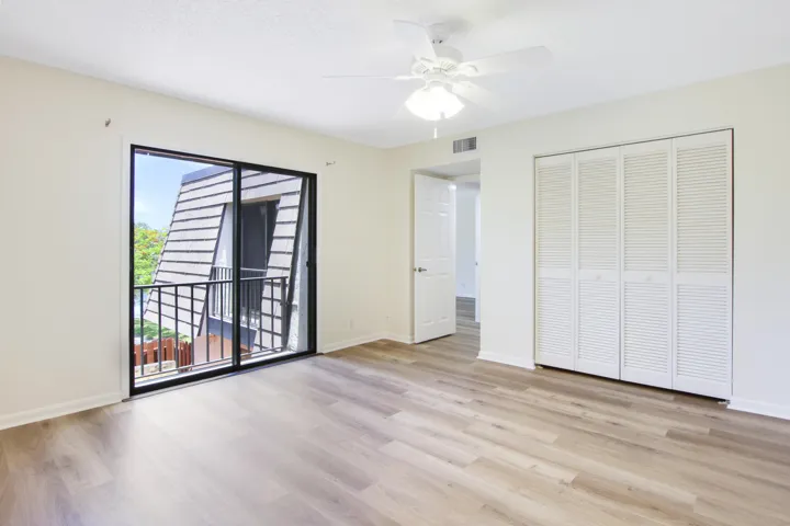 Bedroom 2 offers a sliding glass door that overlooks the patio and ample closet space.