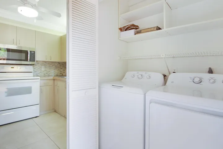 The laundry machines are tucked away in a closet near the kitchen.