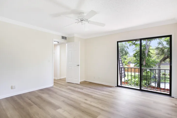 Luxury vinyl flooring covers the stairs and both bedrooms and sliding glass doors overlook the patio.