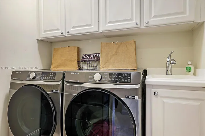 Laundry room with sink and cabinet storage.