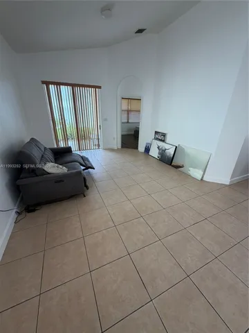 This is the living room with the patio in the background on the left and the primary suite on the right.