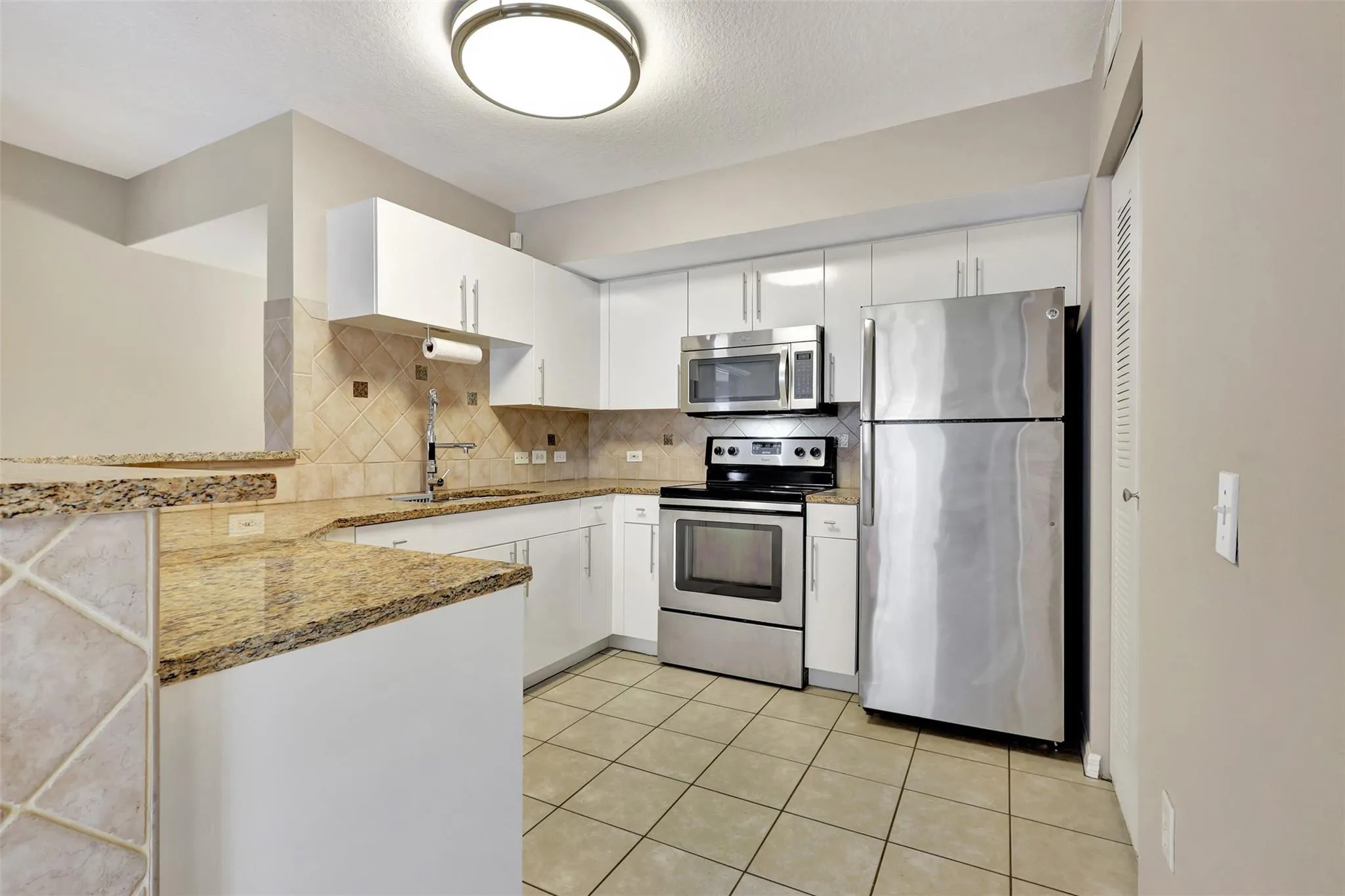 The Kitchen has been updated with White Cabinets, Granite Counter Tops, and Stainless Steel Appliances