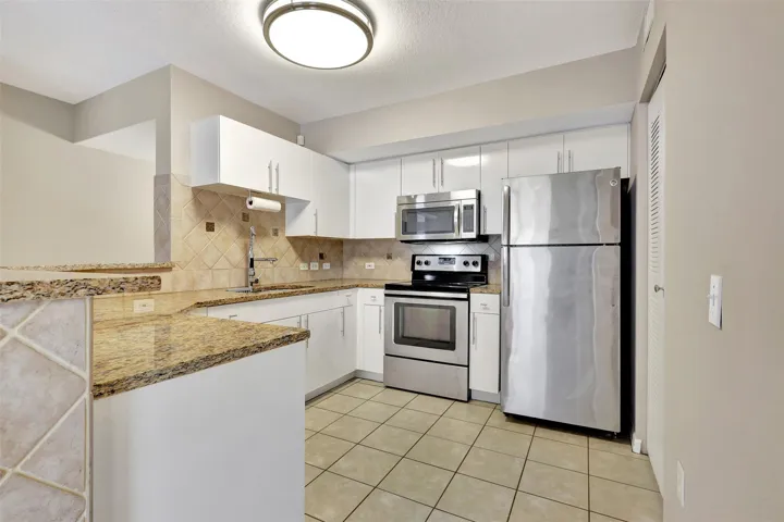 The Kitchen has been updated with White Cabinets, Granite Counter Tops, and Stainless Steel Appliances