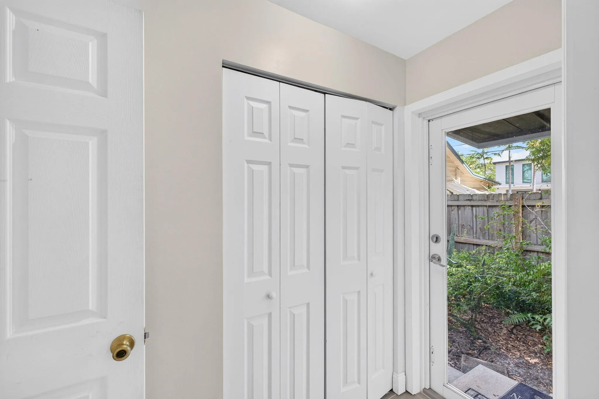 Hallway to primary bedroom and impact door to backyard