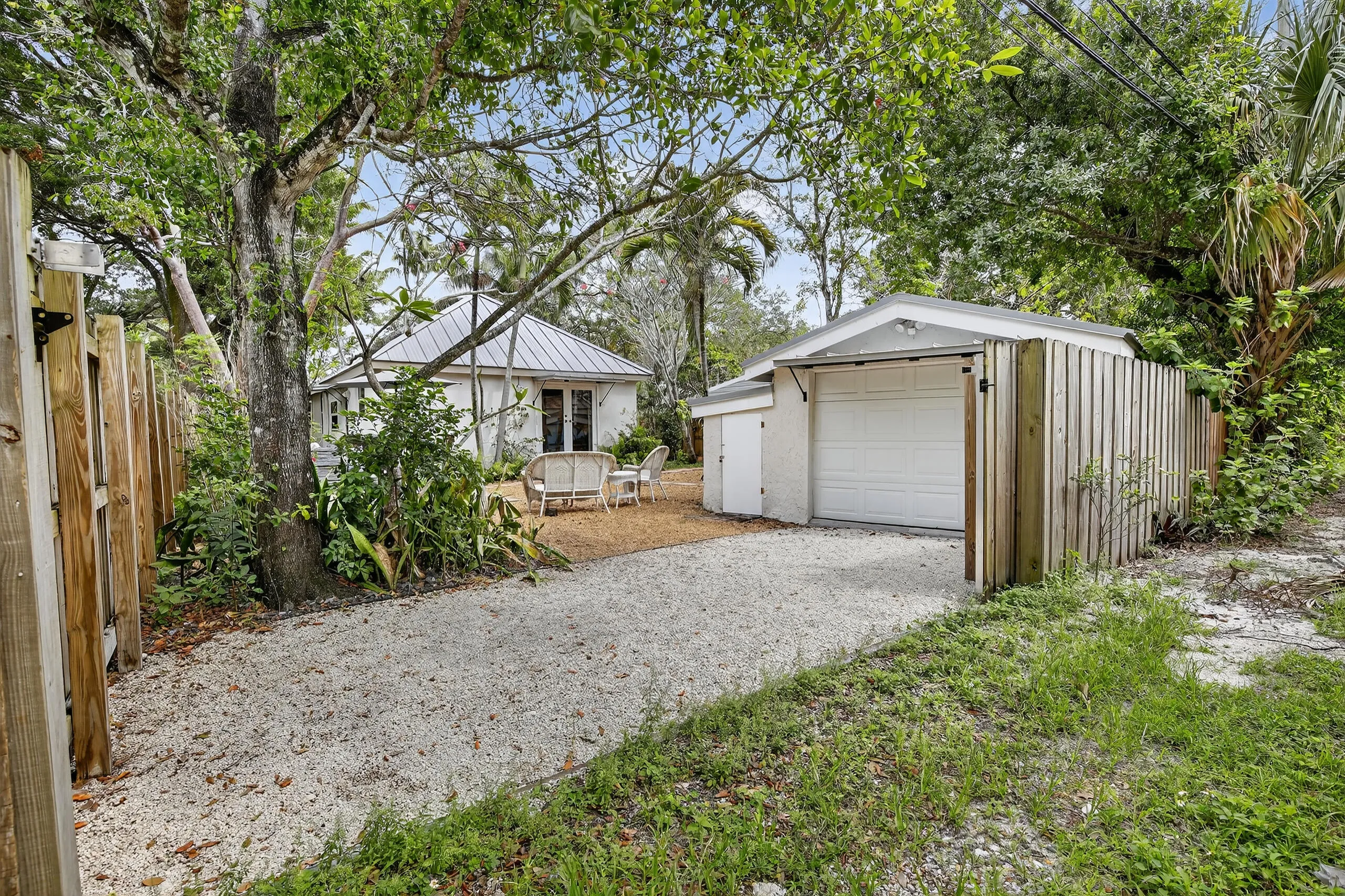 View from alley into backyard and graveled space for car or boat.