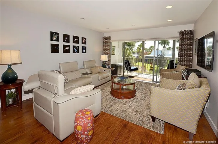 The bright, open living room offers plenty of space to relax or entertain, with sliding glass doors that seamlessly connect to the screened lanai and bring in beautiful natural light.