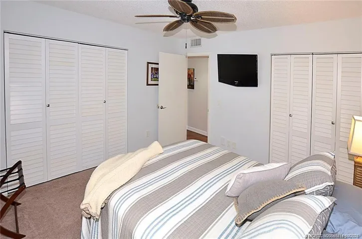 The inviting guest bedroom offers a relaxing retreat for family and visitors, featuring soft natural light, a ceiling fan, and plenty of space for comfortable accommodations.