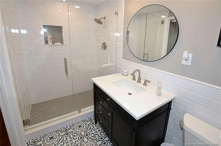 Step into this beautifully renovated bathroom with a sleek glass-enclosed shower, timeless subway tile, and designer finishes that create a fresh, spa-like feel