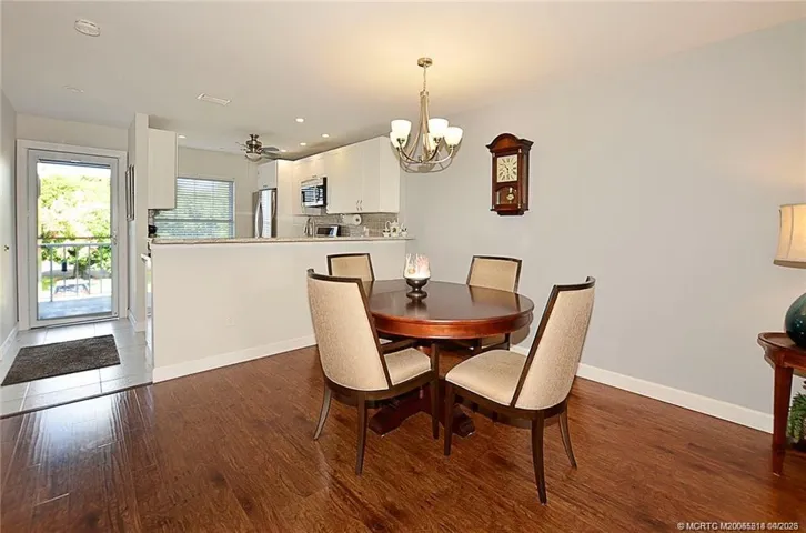 Light and bright dining area flows seamlessly into the updated kitchen featuring white cabinetry, granite countertops, stainless steel appliances, and a convenient breakfast bar that will seat six!