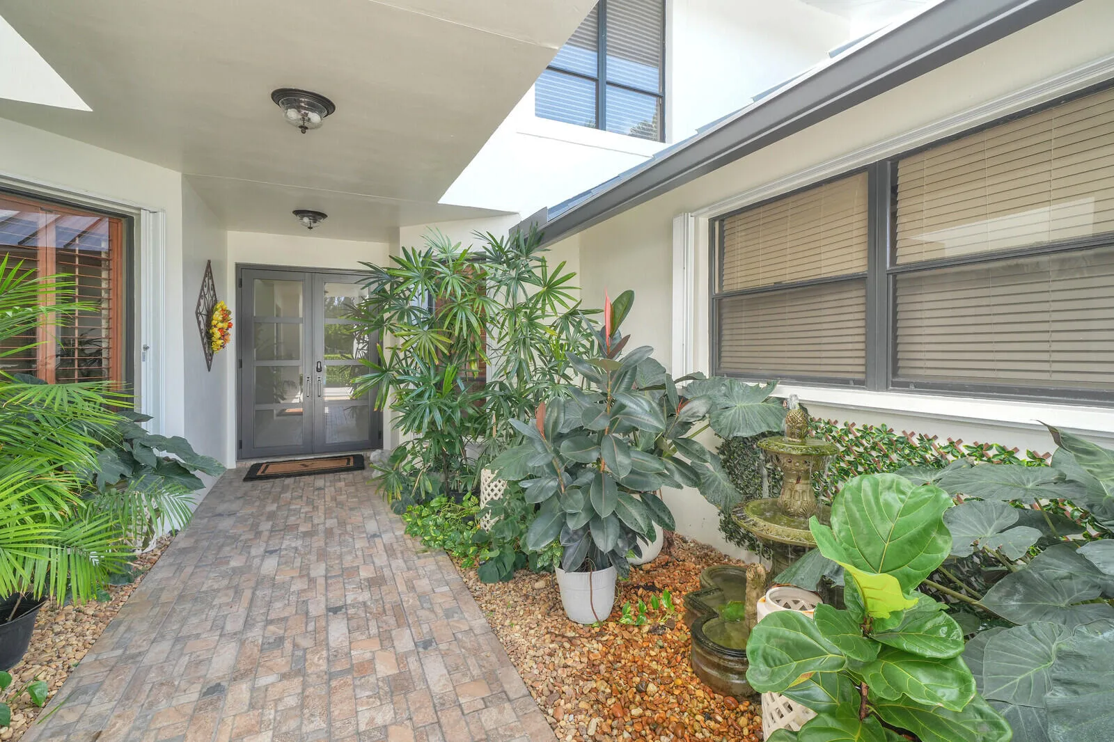 Lush entry with fountain courtyard