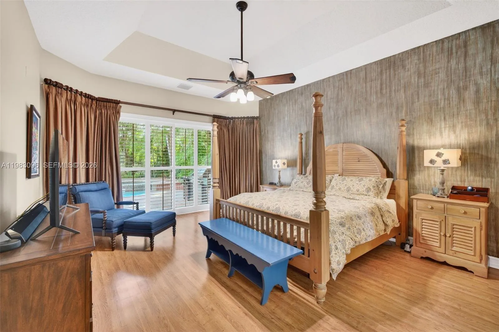 Primary Bedroom w/ sitting area and plantation shutters and room darkning drapes with volume tray ceiling Primary Bedroom w/ sitting area and plantation shutters and room darkning drapes with volume tray ceiling