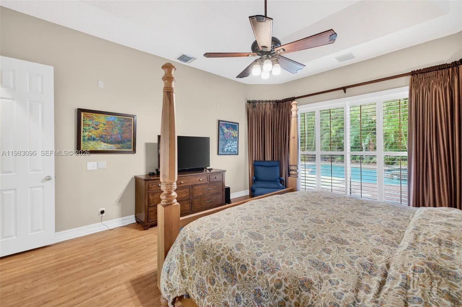 Primary Bedroom w/ sitting area and plantation shutters and room darkning drapes with volume tray ceiling Primary Bedroom w/ sitting area and plantation shutters and room darkning drapes with volume tray ceiling