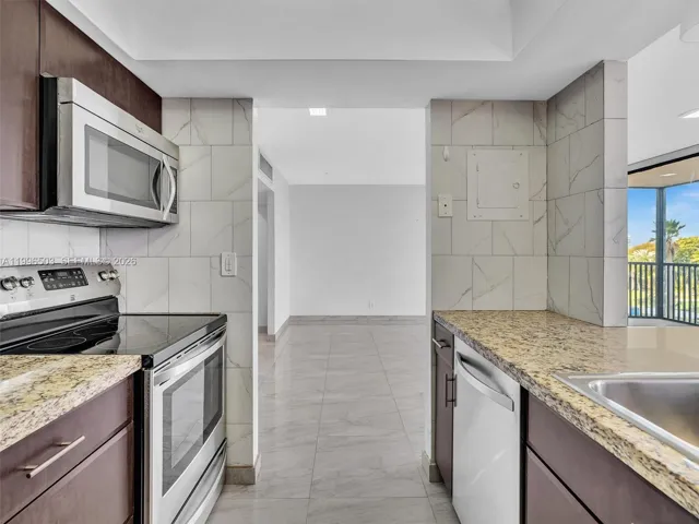 View into Kitchen with granite countertops and stainless steel appliances