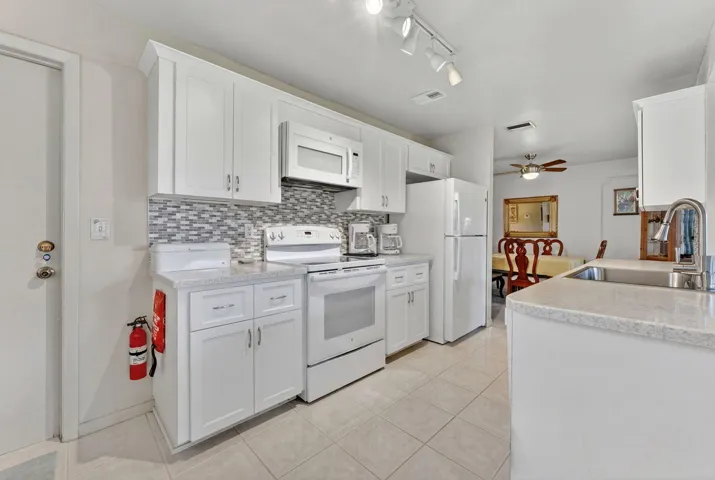 White Shaker Cabinets, White appliances and Corian Counter tops
