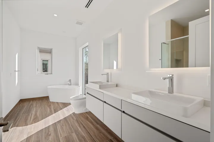 Spacious primary bathroom with dual sinks, ample storage and spa-style soaking tub.
