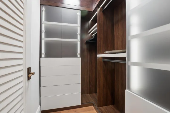 Custom walk-in-closet with recessed accent lighting