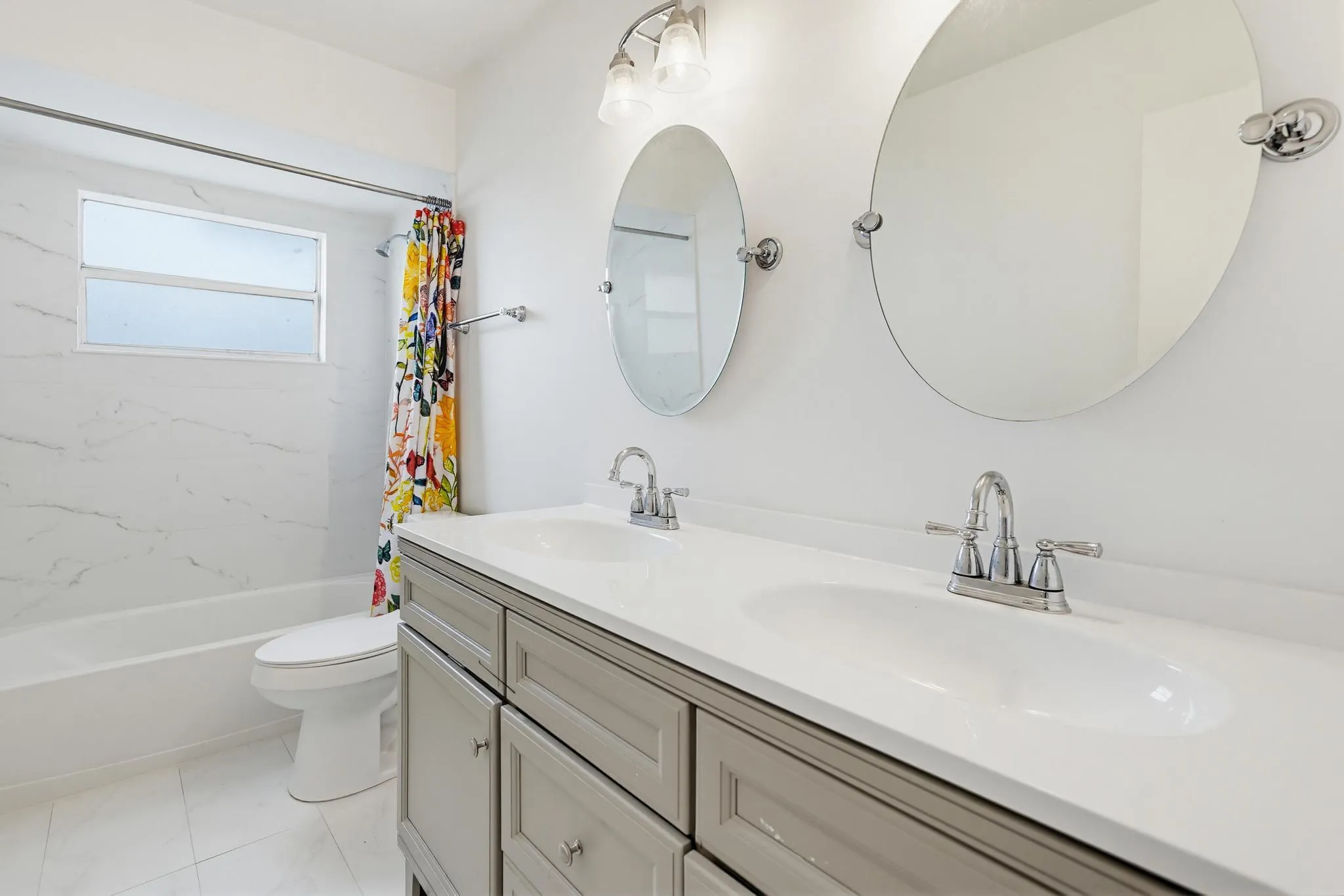 Newer shower, walls , tub and vanity with double sinks and updated tile floors and lighting