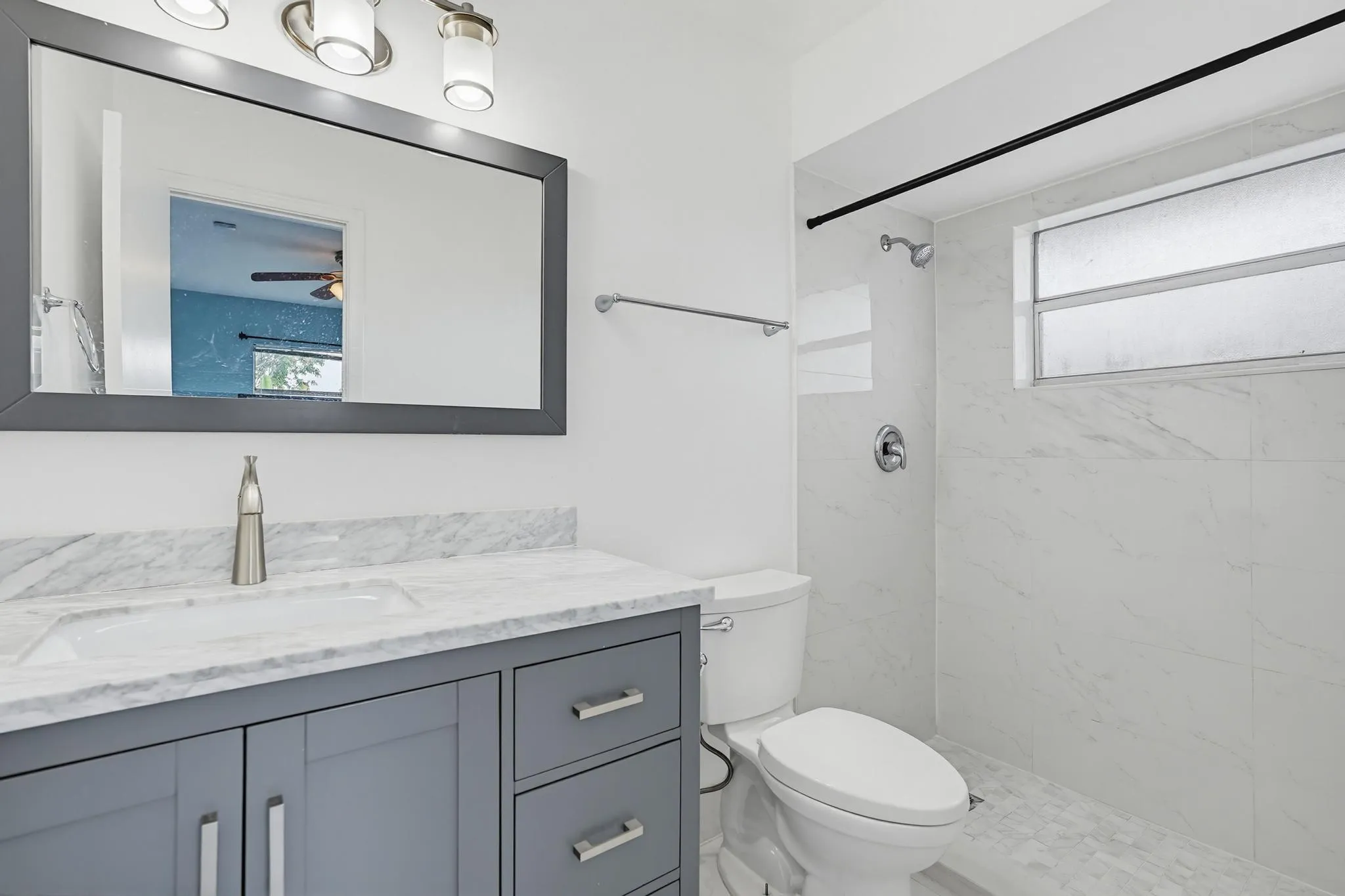 Updated shower tile walls and floor with charming vanity