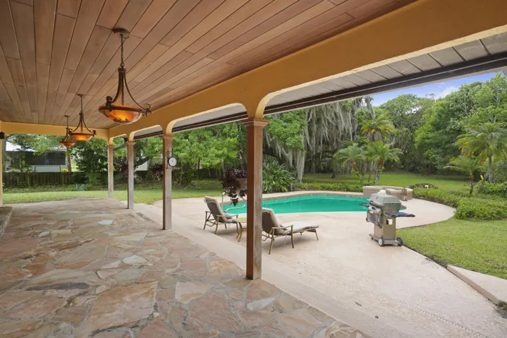 Beautiful poolside stone patio with designer chandeliers.