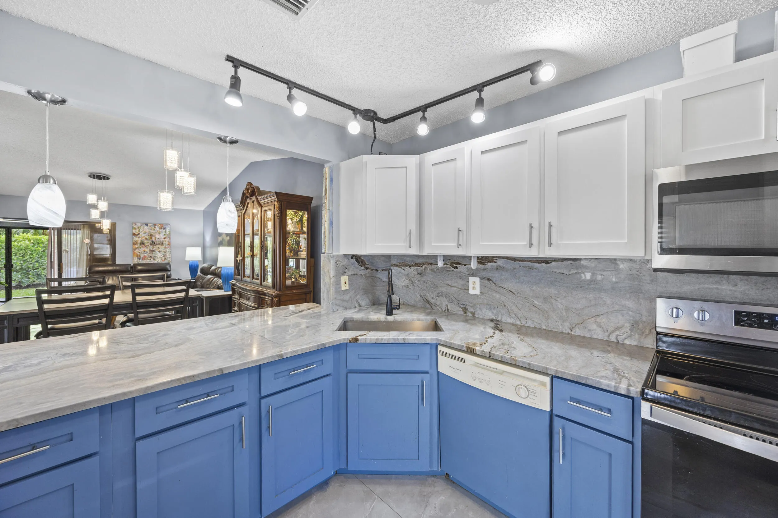Updated kitchen with modern finishes, featuring sleek cabinetry, ample counter space, and a functional layout that opens seamlessly to the dining and living areas—perfect for both everyday living and entertaining.