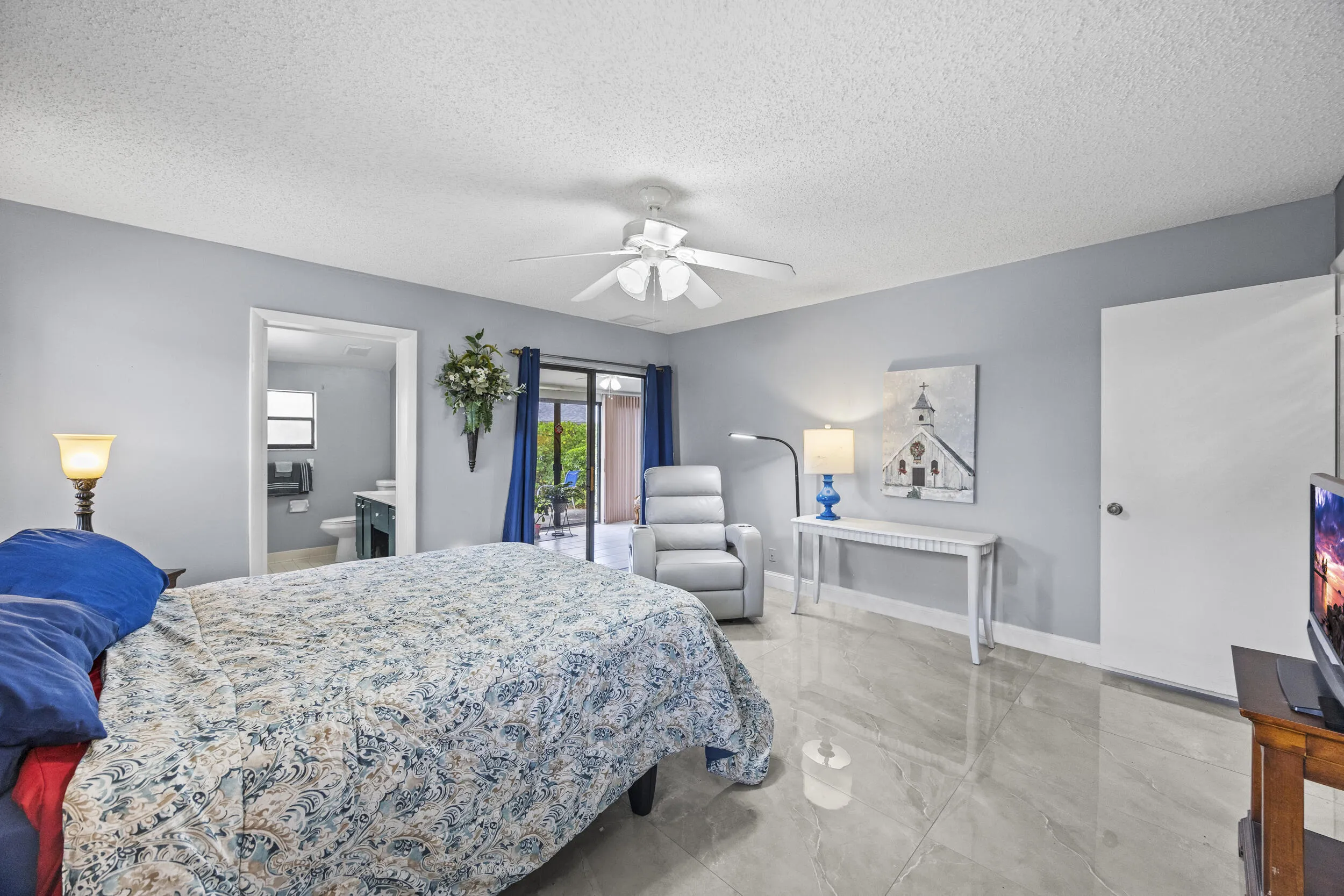 Spacious and serene primary suite featuring sleek tile flooring throughout, offering a clean, modern feel with easy maintenance. This light-filled retreat includes a private ensuite bathroom, generous closet space, and sliding glass doors that open to the outdoor patio—creating a seamless indoor-outdoor connection.