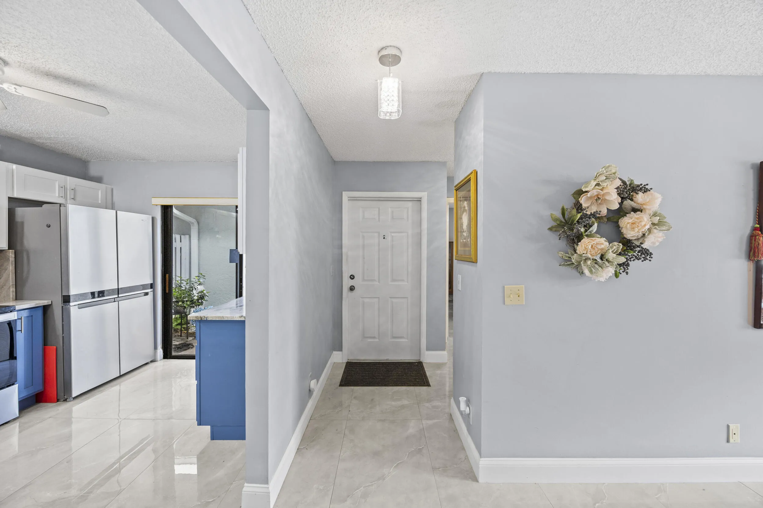 Clean and welcoming interior entry with a bright, open feel, complemented by sleek tile flooring that carries seamlessly into the main living areas.