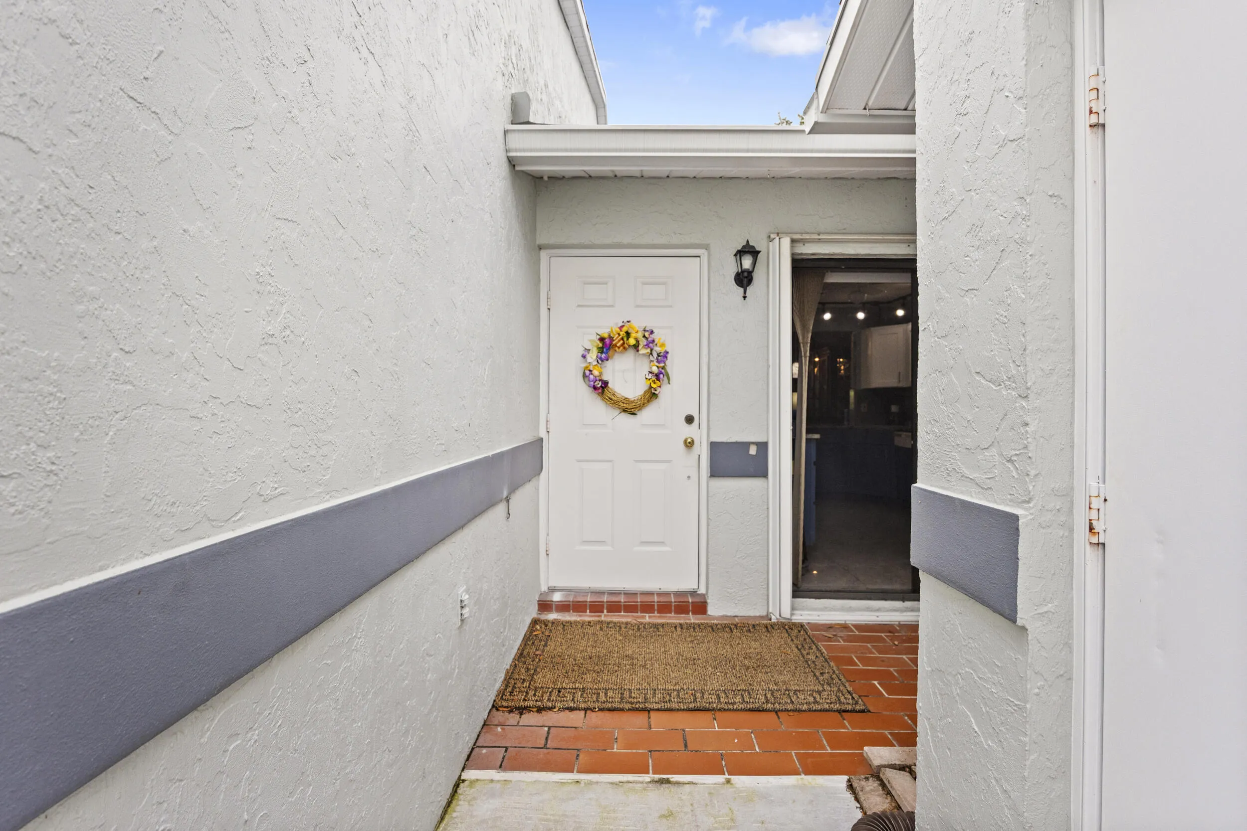 Private, welcoming entry with a charming courtyard feel, featuring a quaint garden space that adds a touch of character and a warm first impression as you arrive.
