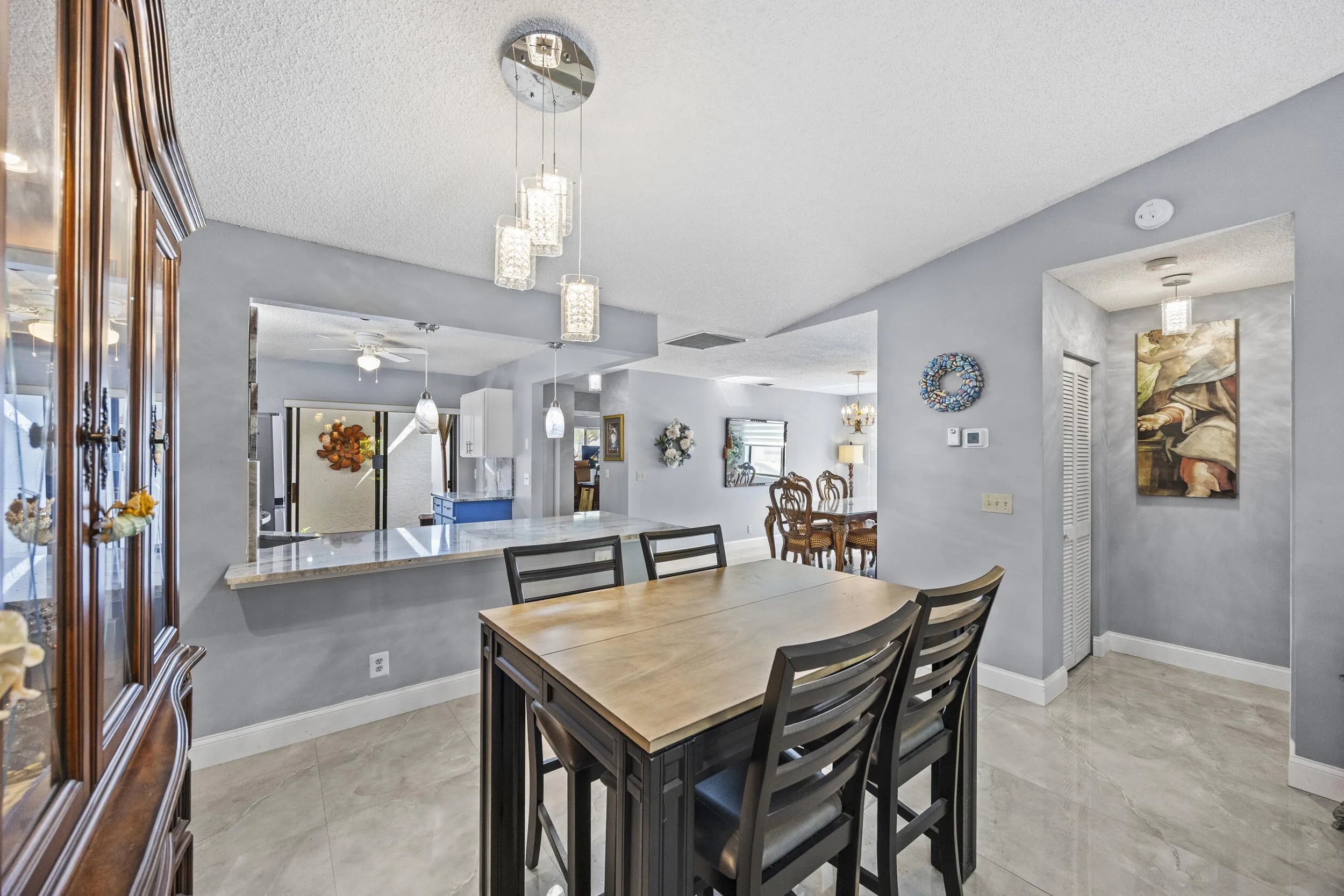 Bright, open-concept living and dining space with soaring ceilings and sleek tile flooring throughout, creating a spacious feel that’s perfect for both everyday living and entertaining.