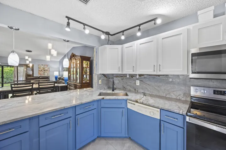 Updated kitchen with modern finishes, featuring sleek cabinetry, ample counter space, and a functional layout that opens seamlessly to the dining and living areas—perfect for both everyday living and entertaining.