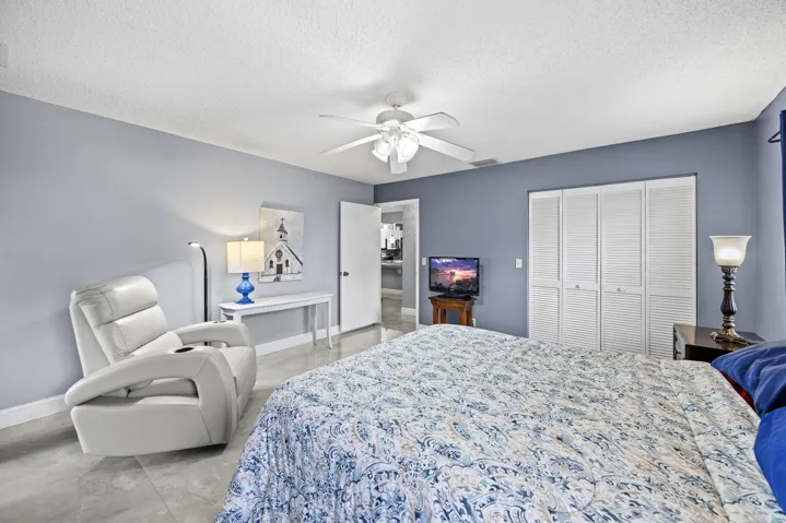 Spacious and serene primary suite featuring sleek tile flooring throughout, offering a clean, modern feel with easy maintenance. This light-filled retreat includes a private ensuite bathroom, generous closet space, and sliding glass doors that open to the outdoor patio—creating a seamless indoor-outdoor connection.