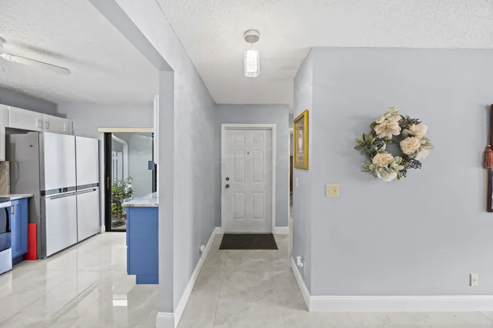 Clean and welcoming interior entry with a bright, open feel, complemented by sleek tile flooring that carries seamlessly into the main living areas.